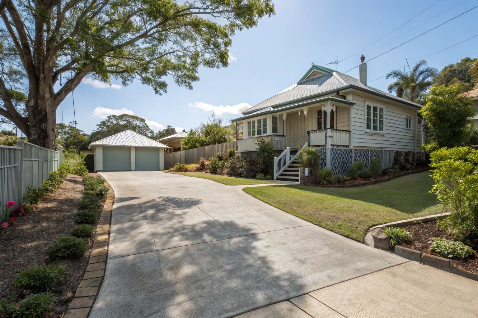 A freshly finished concrete driveway leading to a charming older-style Robertson Brisbane home with established gardens