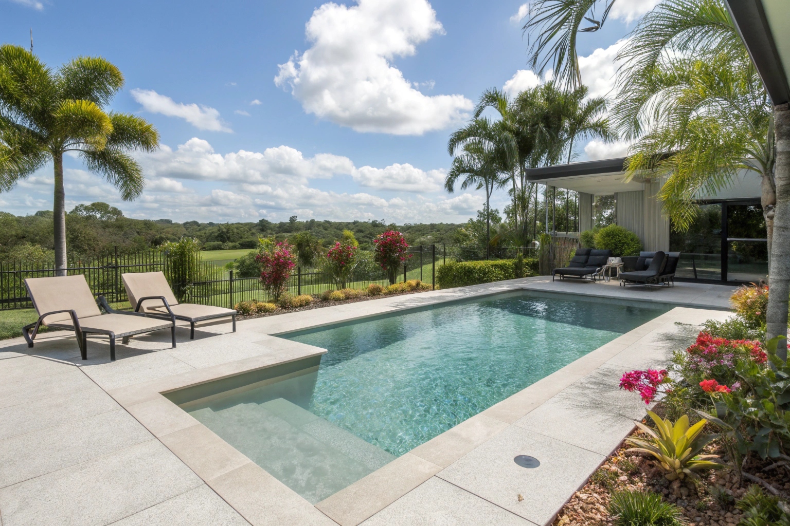 Polished concrete pool surround with crystal clear water, modern outdoor furniture, tropical landscaping in Pallara